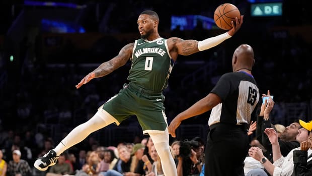 Bucks’ Damian Lillard saves the ball from going out of bounds in NBA preseason game vs. Lakers.
